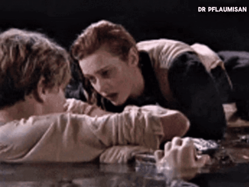 Man And Woman Laying On Table With Dr Pflaumisan GIF