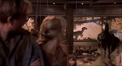 Man And Woman Looking At Dinosaur Display GIF