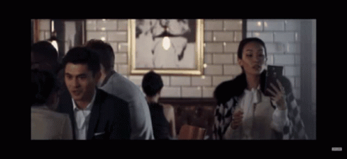 Man and Woman Looking at Phones in Restaurant
