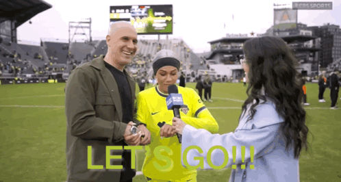 Man and Woman on Soccer Field Saying Let's Go