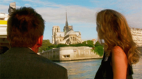 Man And Woman Overlooking Cathedral By Water GIF