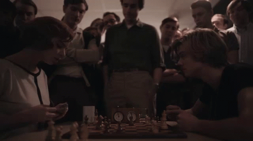 Man and Woman Playing Chess With Crowd Watching