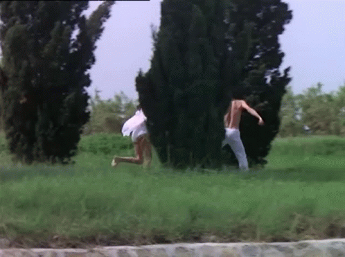 Man and Woman Running in Grassy Field