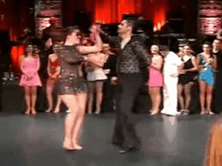 Man And Woman Salsa Dancing With People Around GIF