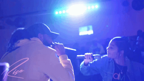 Man and Woman Singing Into Microphones Rise