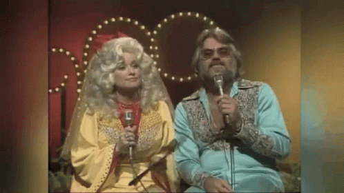 Man and Woman Singing Into Microphones