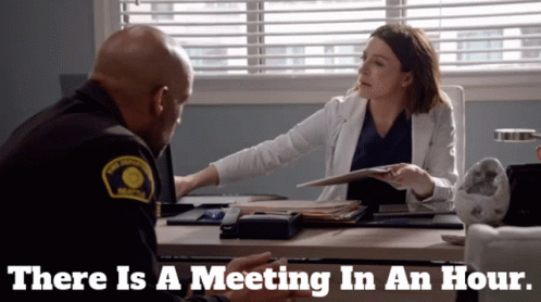 Man and Woman Sitting at Desk There Is a Meeting in an Hour