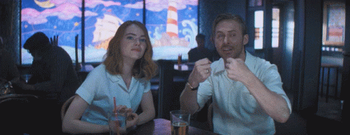 Man And Woman Sitting At Table Eating And Drinking GIF