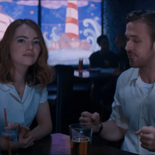 Man And Woman Sitting At Table With Beer GIF