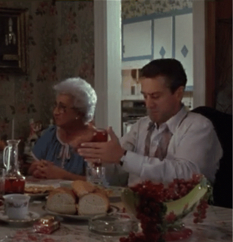 Man and Woman Sitting at Table With Food and Drinks