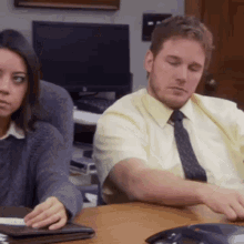 Man and Woman Sitting at Table With Phone