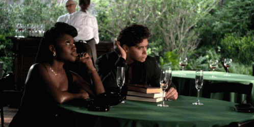 Man and Woman Sitting at Table With Wine Glasses