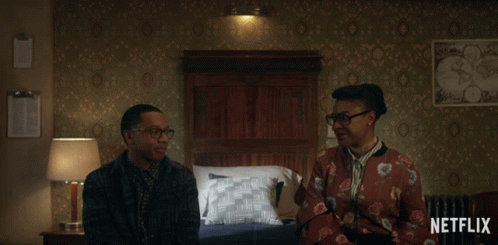 Man And Woman Sitting In Bedroom With Netflix Logo GIF