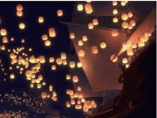 Man And Woman Sitting In Boat Looking At Lanterns GIF