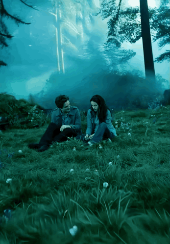 Man and Woman Sitting in Forest Grass