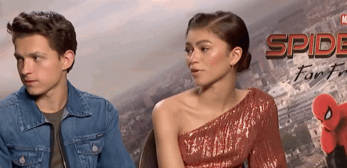 Man And Woman Sitting In Front Of Spider-Man Poster GIF