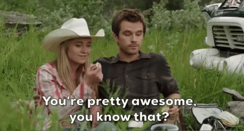 Man And Woman Sitting In Grass With Truck And Cowboy Hat GIF