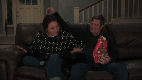 Man and Woman Sitting on Couch Eating Doritos