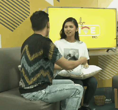Man and Woman Sitting on Couch in Front of TFC TV