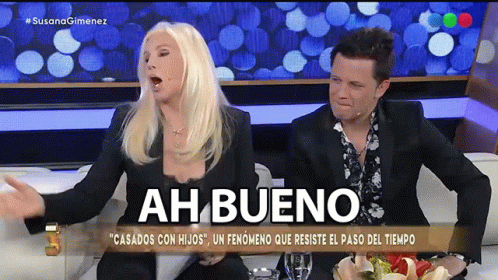 Man And Woman Sitting On Couch Saying Ah Bueno GIF