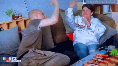 Man and Woman Sitting on Couch With Hartz on Bottom Right