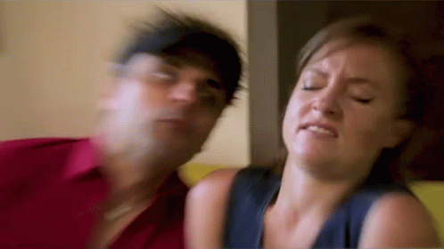 Man and Woman Sitting on Couch Woman Making Face