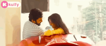 Man and Woman Sitting on Red Car