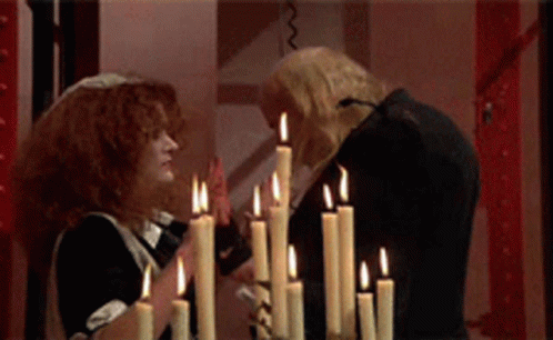 Man And Woman Standing In Front Of Candles GIF
