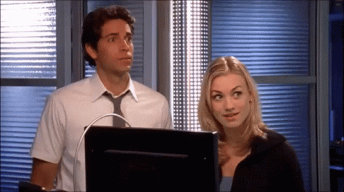 Man and Woman Standing in Front of Computer Monitor