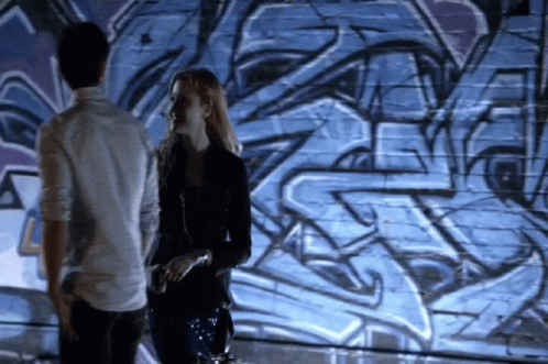 Man and Woman Standing in Front of Graffiti Wall