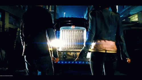 Man and Woman Standing in Front of Transformers Semi Truck