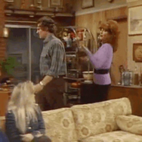 Man and Woman Standing in Living Room with Couch