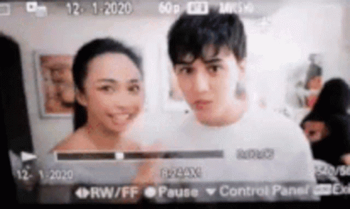 Man and Woman Standing Next to Camera Screen