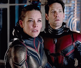 Man and Woman Standing Next to Each Other Looking at Camera