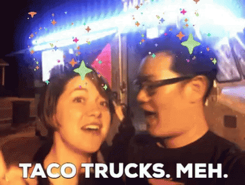 Man and Woman Standing Next to Taco Trucks Meh