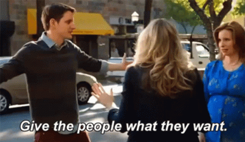 Man and Woman Talking on Street Saying Give the People What They Want