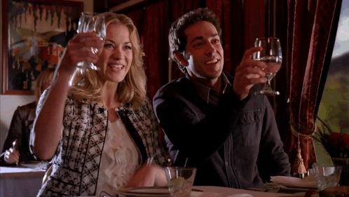 Man and Woman Toasting With Wine Glasses in Restaurant