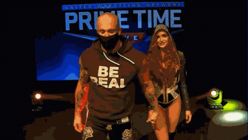 Man And Woman Walking In Front Of Home Time Live Sign GIF