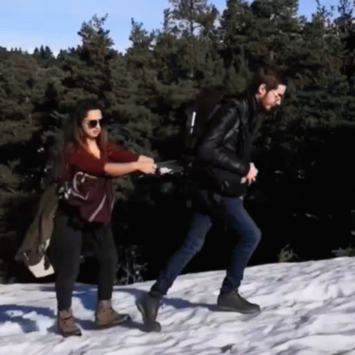 Man And Woman Walking In Snow Holding Hands GIF