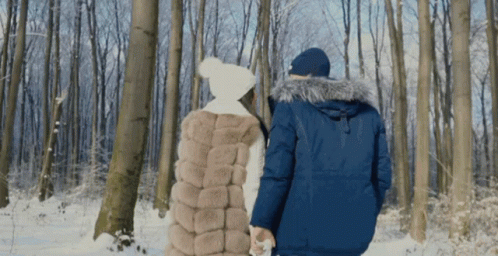 Man and Woman Walking Through Snow