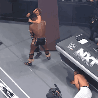 Man and Woman Wrestling in Front of NXT Sign