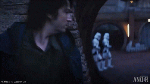 Man at Brick Wall With Stormtroopers Walking