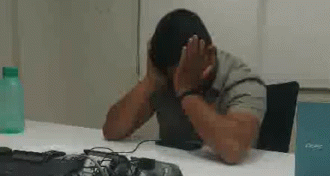Man At Desk With Hands On Face GIF