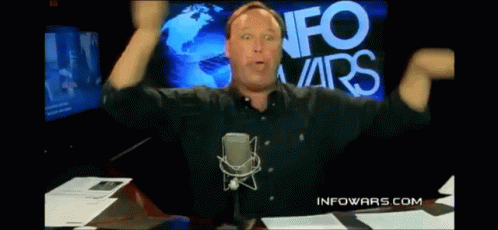 Man at Microphone in Front of Info Wars Screen