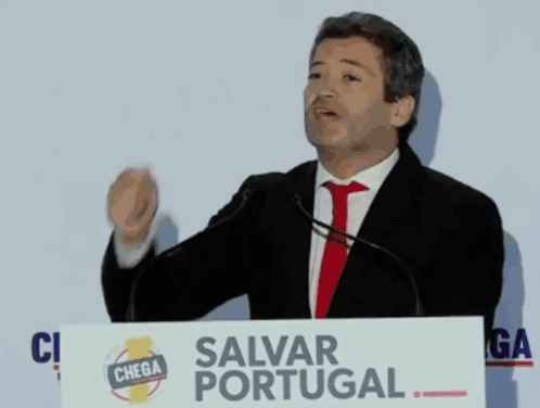 Man At Podium With Salvar Portugal Sign GIF