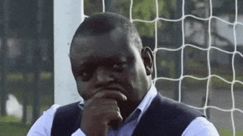 Man at Soccer Net Hand on Chin Looking at Camera