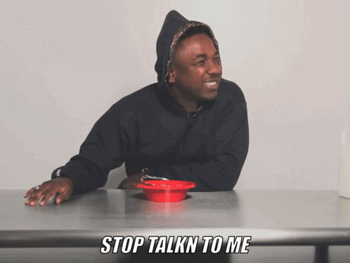 Man at Table With Red Bowl Saying Stop Talkn to Me