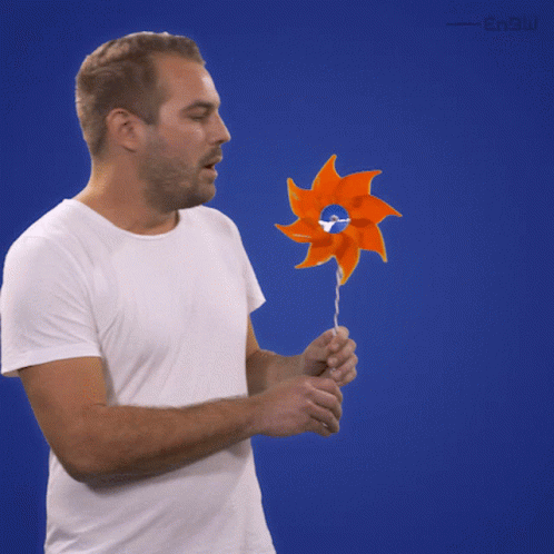 Man Blowing Hand Held Windmill GIF