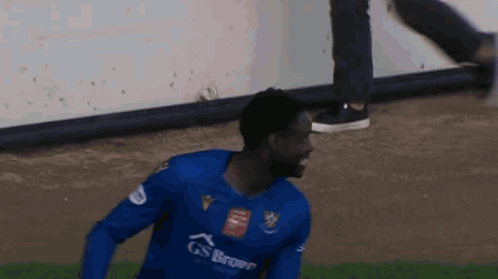 Man Blue Gs Brown Jersey Running on Soccer Field