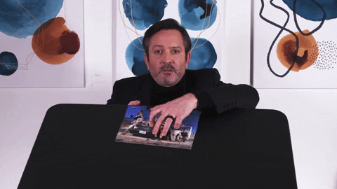 Man Breaking Up A Finished Jigsaw Puzzle GIF